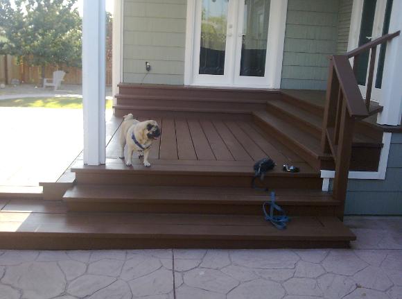 Backyard home remodel Stained two tiered deck with steps to French doors